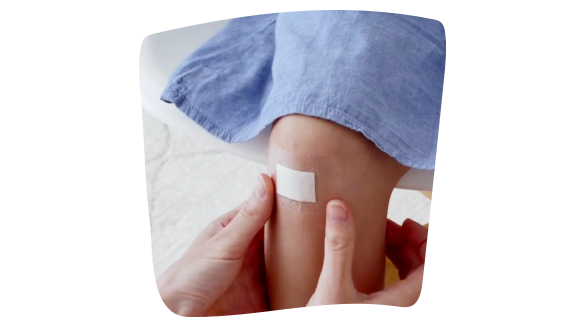 Imagen de una persona poniendo un apósito de primeros auxilios Leukoplast® aqua pro en la rodilla a un niño. Imagen de una persona poniendo un apósito de primeros auxilios Leukoplast® aqua pro en la rodilla a un niño.